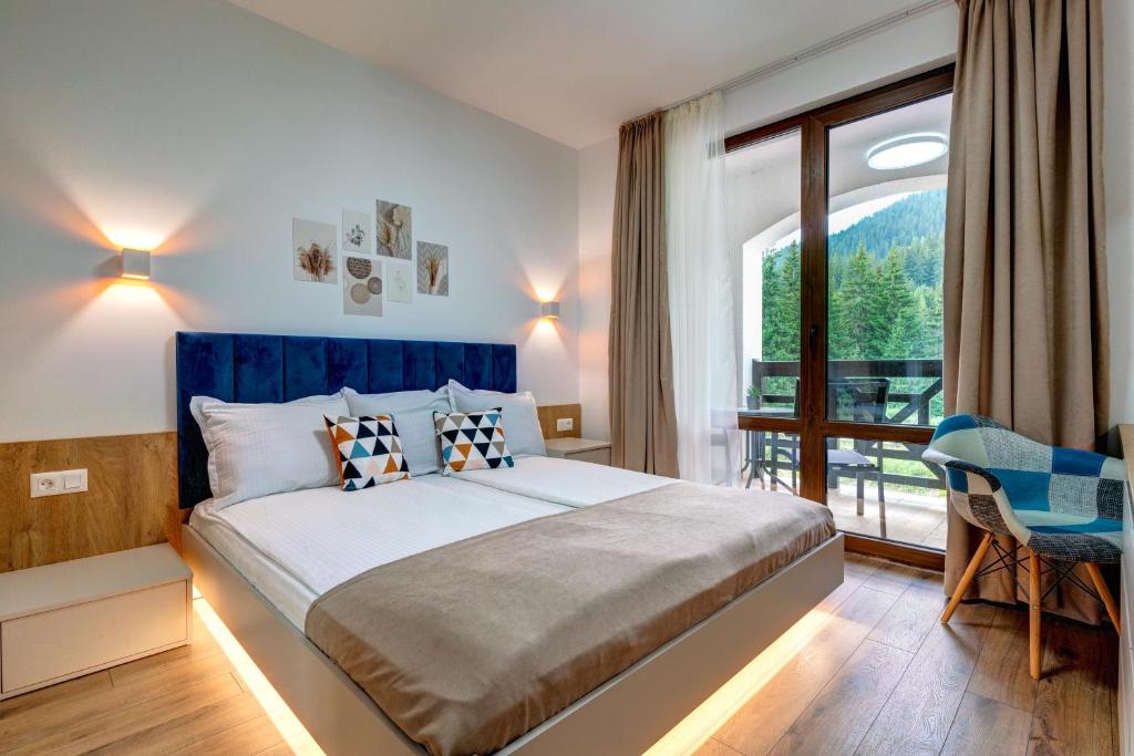 a bedroom with a large bed and a large window at N.Joy Holiday Apartment 532 by Oak Residence in Smolyan