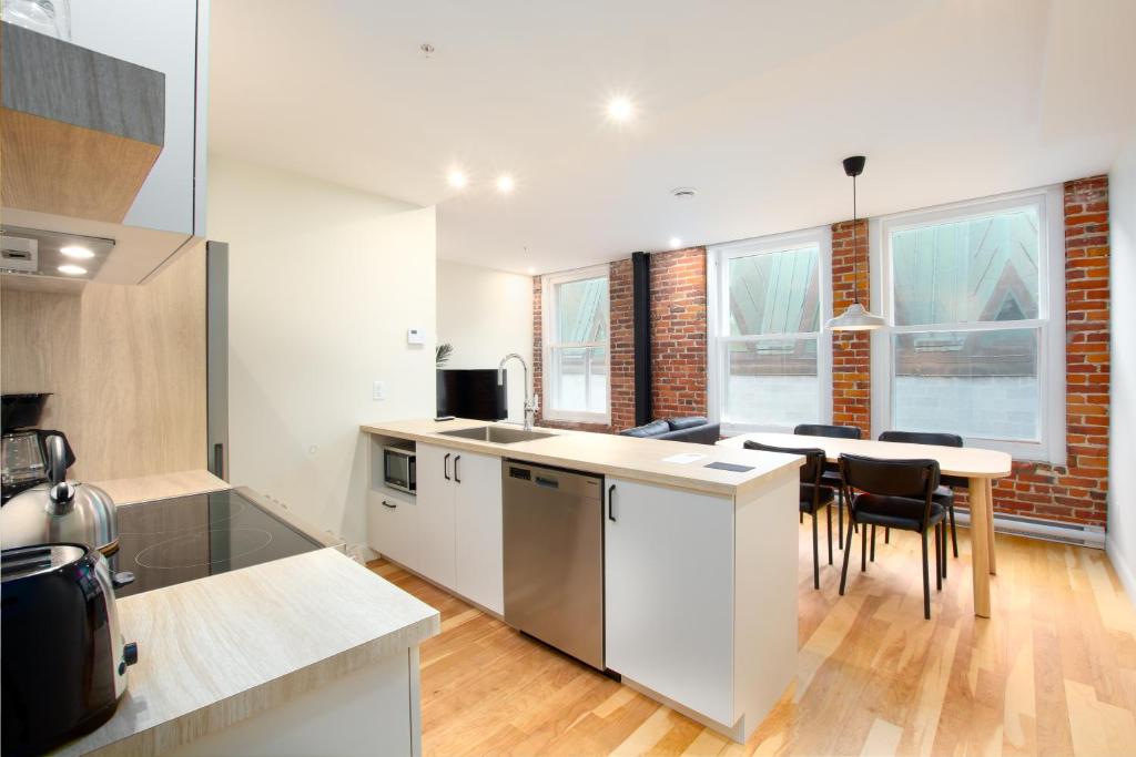 a kitchen and dining room with a table and chairs at Les Lofts de la Barricade - Par les Lofts Vieux-Québec in Quebec City