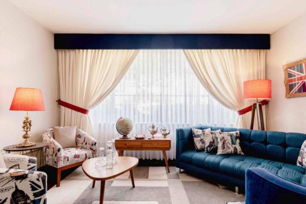 sala de estar con sofá azul y mesa en Británico clásico con aire acondicionado en la sala, en Lima