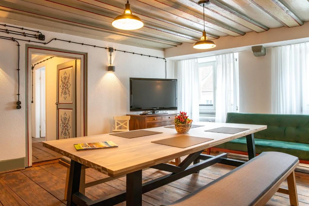 uma sala de estar com uma mesa de madeira e uma televisão em Black Forest Moments inkl. Sauna für 8 Personen em Hüfingen