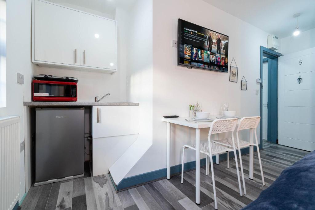 uma pequena cozinha com mesa e cadeiras num quarto em Sky Rooms One Bedroom Modern Studio Apartment 6 em Birmingham