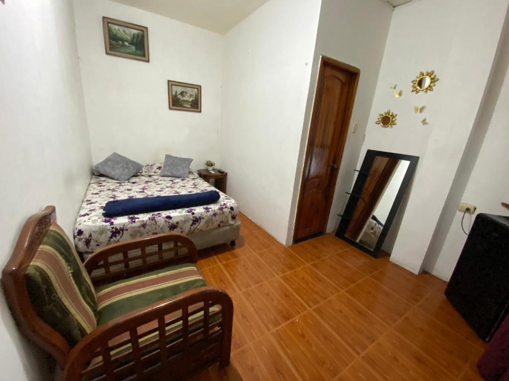 1 dormitorio con 1 cama y 1 silla en UFO House, en Montañita