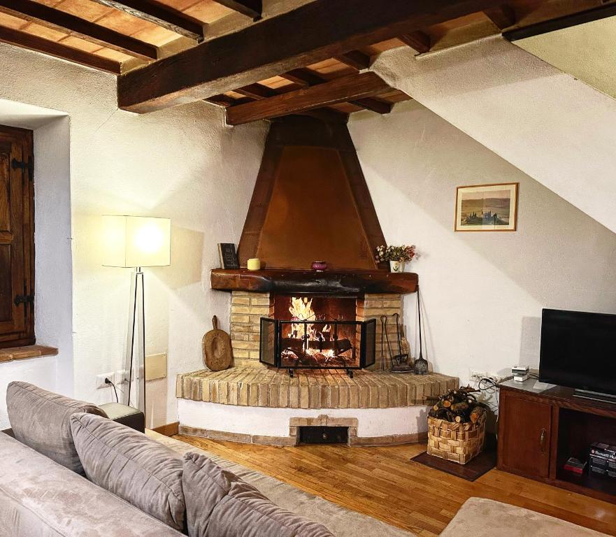 a living room with a stone fireplace in a room at Casa Renata in Arcidosso