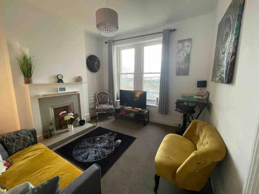 a living room with a yellow chair and a fireplace at One/Two Bedroom Apartment Close to Sea & Centre in Hastings