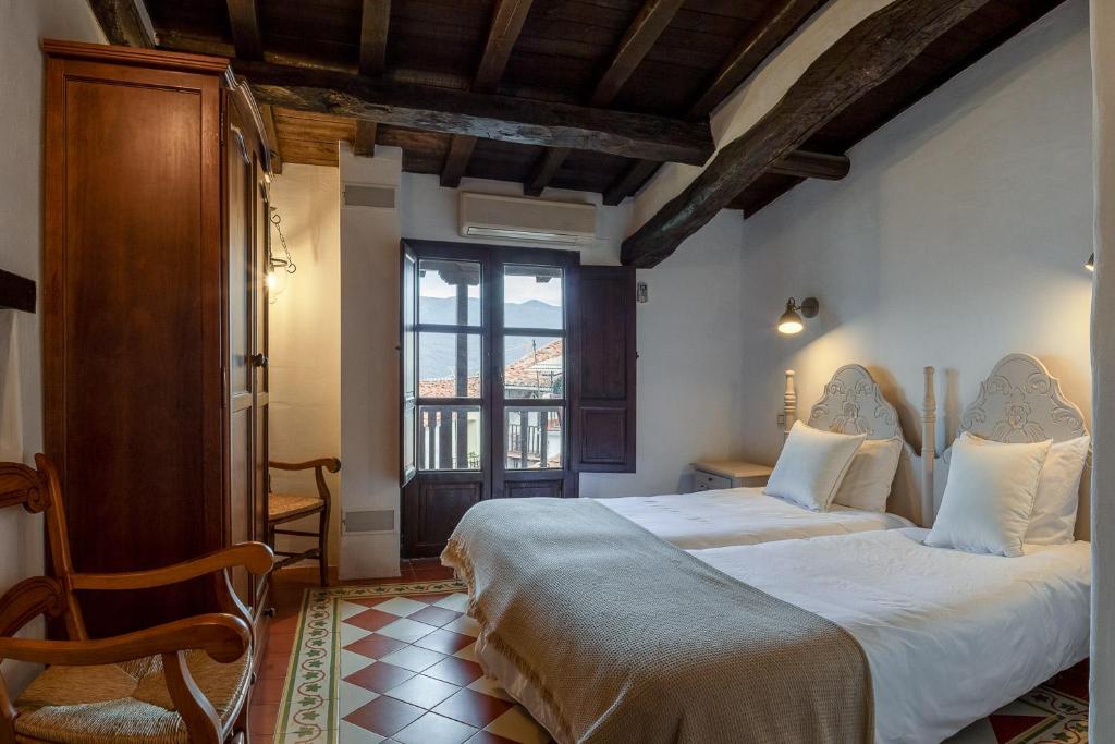 - une chambre avec un grand lit et une fenêtre dans l'établissement Casa rural la grande, à Casas del Castañar