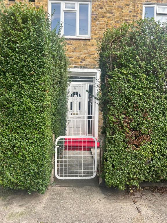 una puerta con un banco rojo frente a un edificio en Spacious bright double room, en Londres