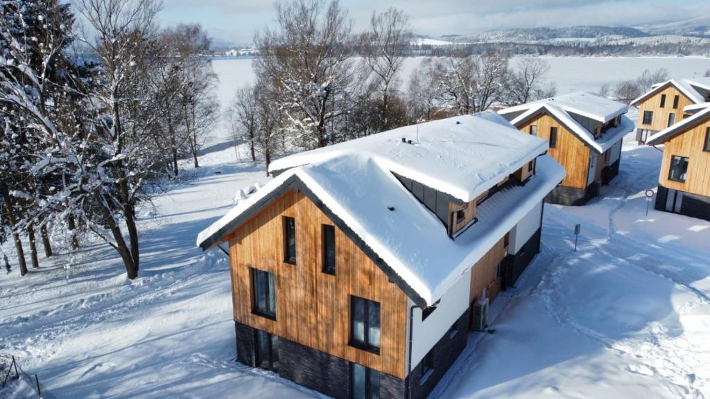 Apartmán Na Břehu Lipna في سيرنا في باسيومافاي: اطلالة جوية على منزل مغطى بالثلوج