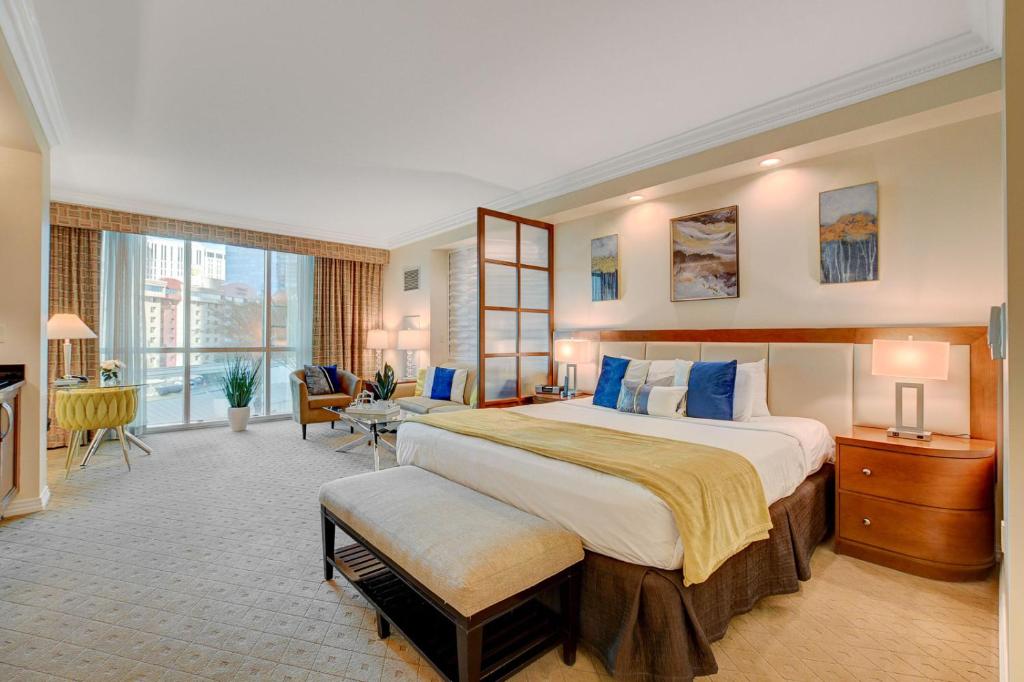 Cette grande chambre comprend un grand lit avec des oreillers bleus. dans l'établissement Sin City Suite @ MGM Signature, à Las Vegas