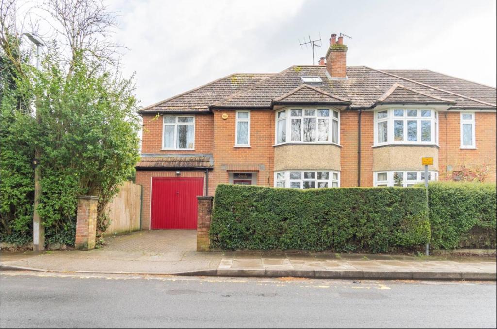 a red brick house with a red garage at Close to Salisbury Cathedral (& Hospital) in Salisbury