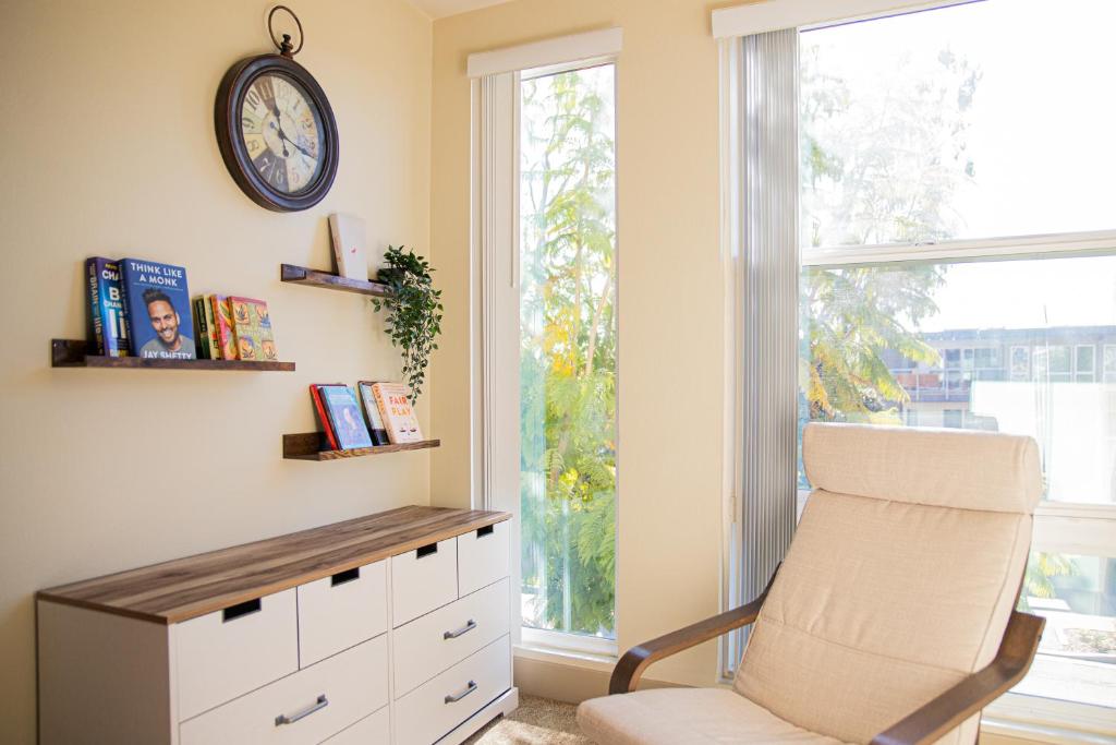 une chambre avec une chaise et un réveil sur le mur dans l'établissement Luxurious Apartment With The Marina View, à Los Angeles