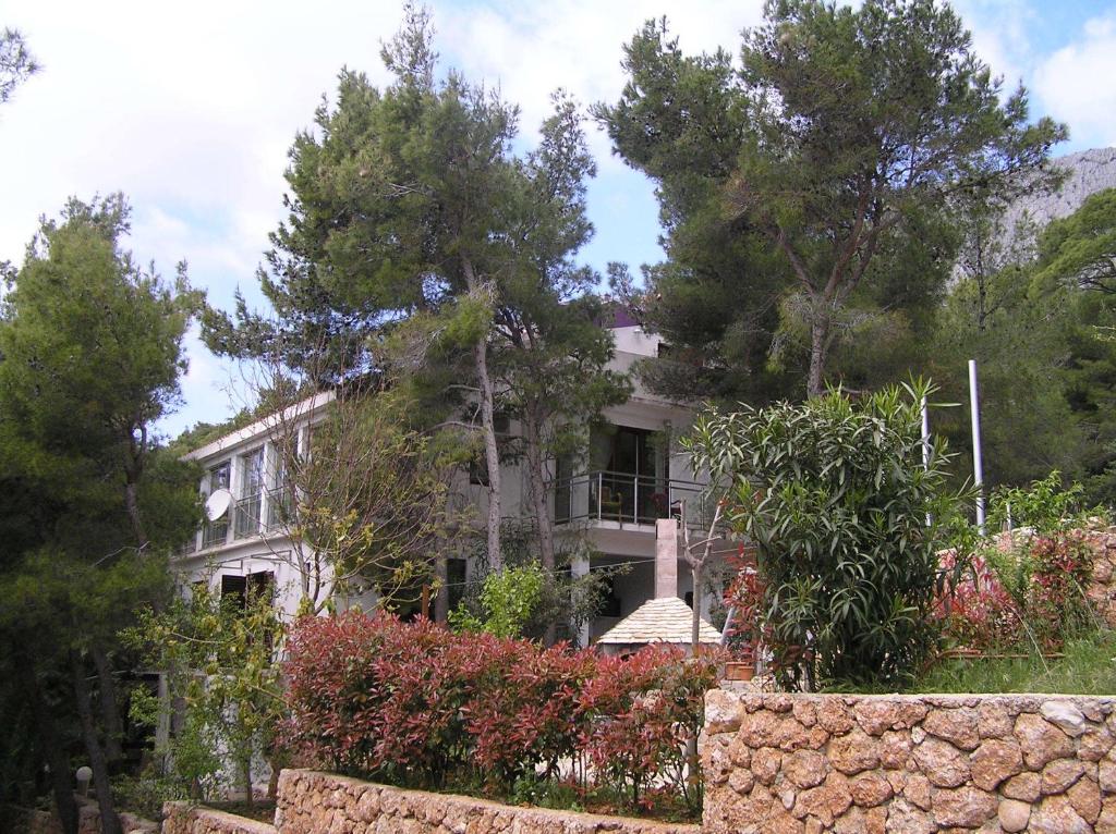 a house with a stone fence in front of it at Apartments Villa Ypsilon in Sveta Nedelja