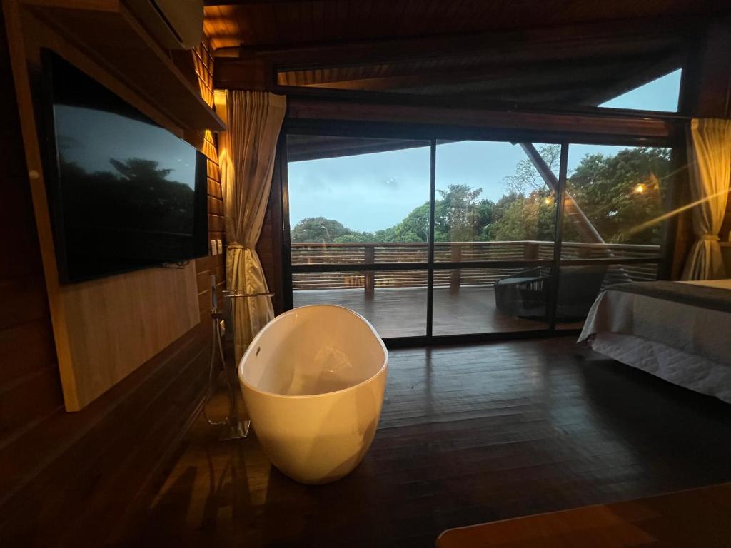 a bath tub in a room with a large window at Paradouro Monã in Torres