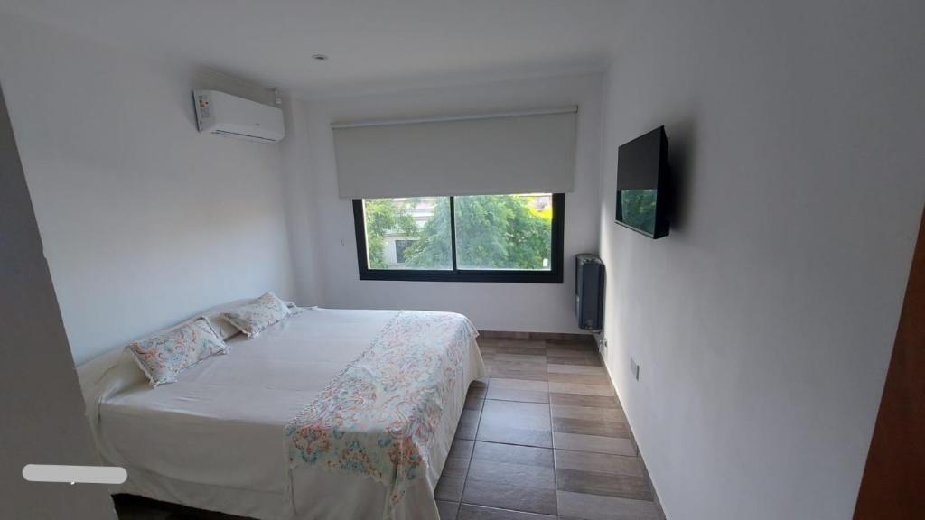 a small bedroom with a bed and a window at La Maruca 631 in Balcarce