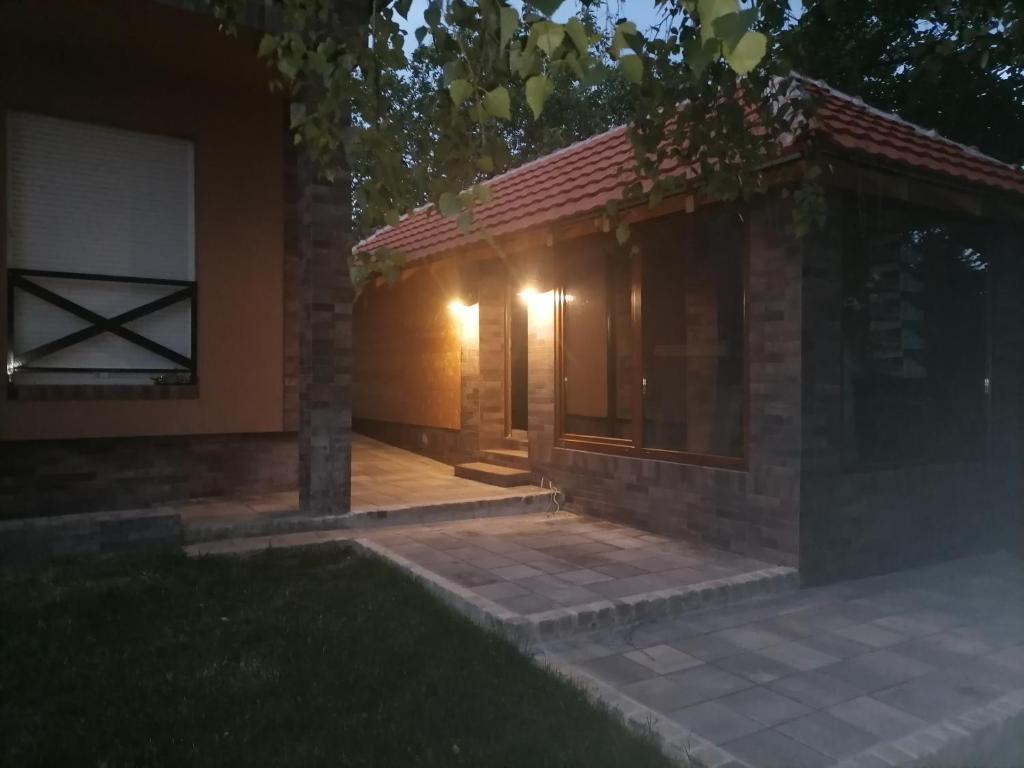 a small house with a porch at night at A Bre Da Bre Family Club in Niš