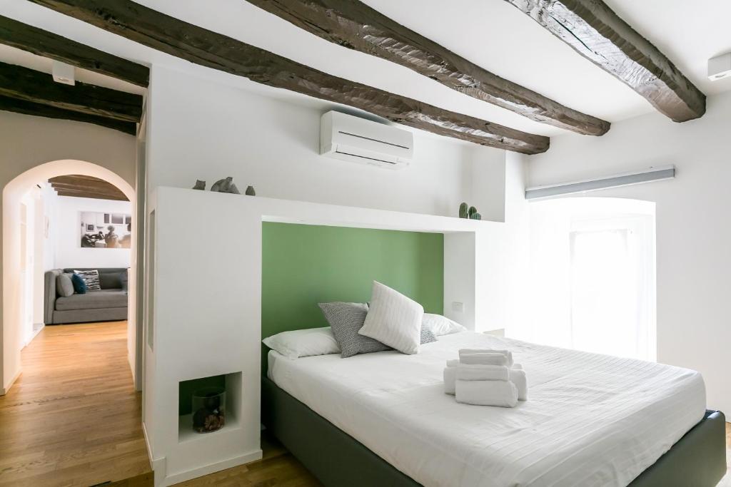 a bedroom with a large white bed with a fireplace at Mortara Navigli Apartments in Milan