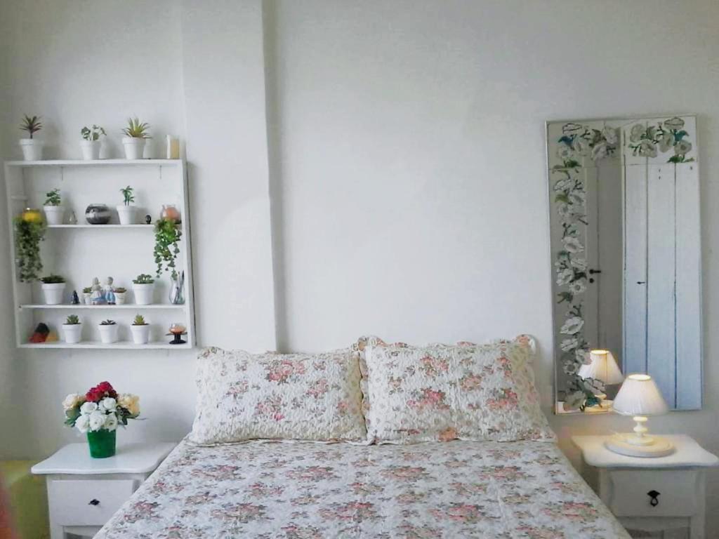 a bedroom with a bed with flowers on it at Sun Apartamento Copacabana in Rio de Janeiro