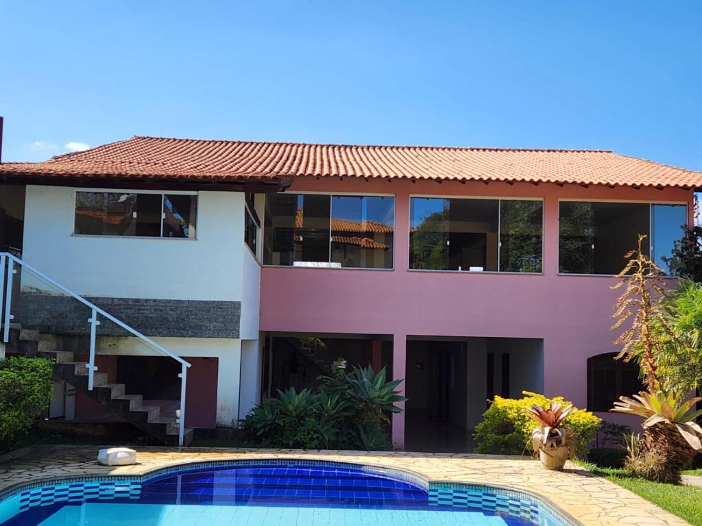 una casa con piscina frente a ella en Pousada Aconchego 2 en Miguel Pereira