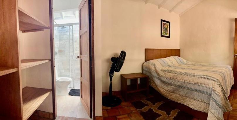 um quarto com uma cama e uma porta de vidro em Hospedaje La Casita de Maria em Barichara