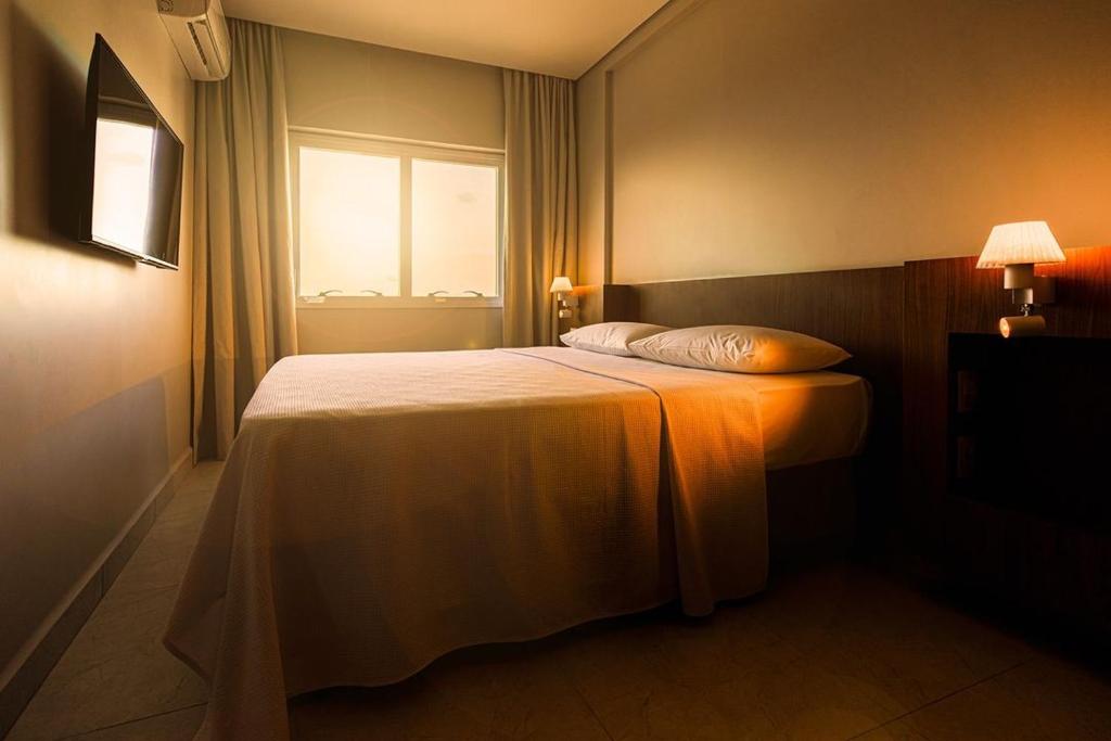 a bedroom with a large bed with a window at Salinas Exclusive Resort in Salinópolis