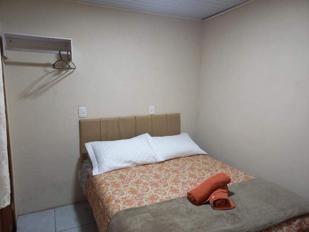 um pequeno quarto com uma cama com uma toalha em Jardim Temporadas em Canela