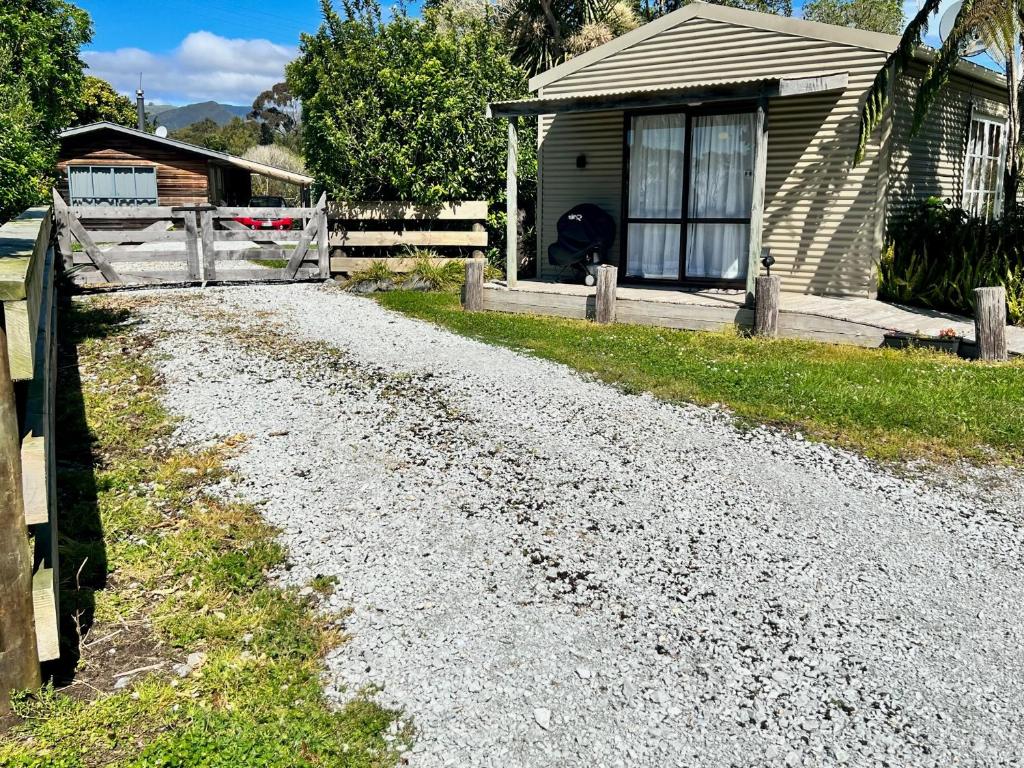 a gravel road in front of a house at Bay Cottage - Takaka Holiday Unit in Takaka