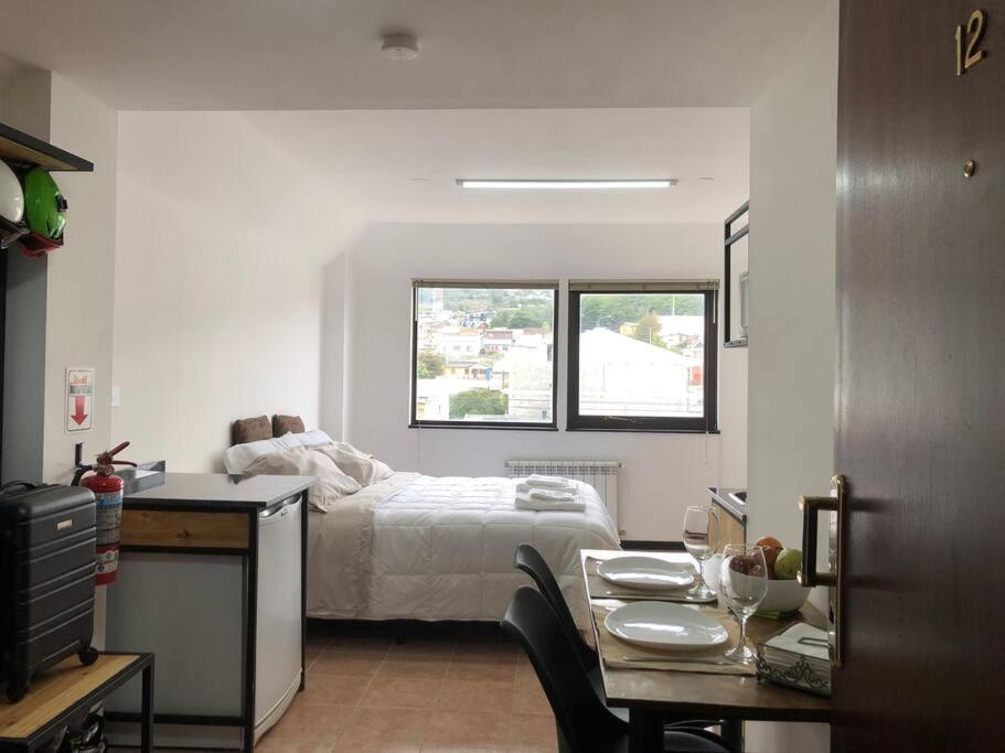 Schlafzimmer mit einem Bett und einem Tisch mit einem sidx sidx sidx in der Unterkunft Al fin un mundo in Ushuaia