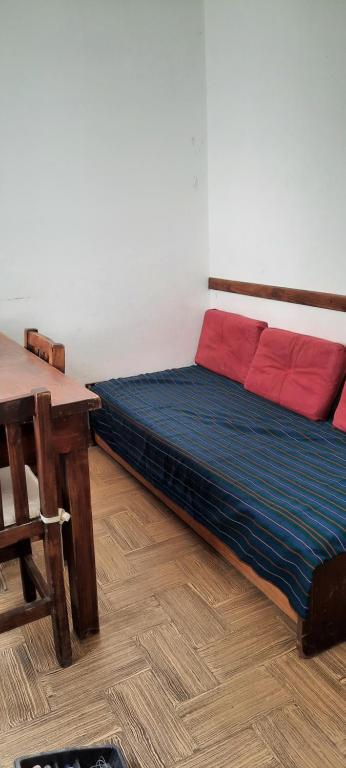 Cama en habitación con mesa de madera en departamento centrico en Mar del Plata