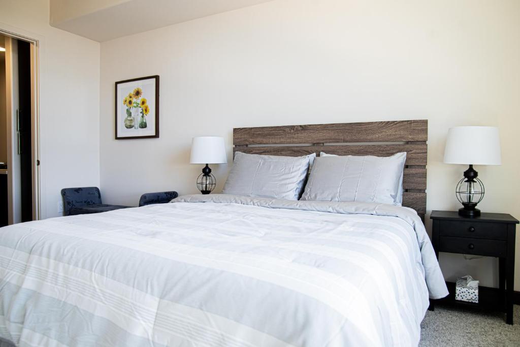 洛杉磯的住宿－One Bedroom Gem In Weho，一间卧室配有一张带两盏灯的大型白色床。