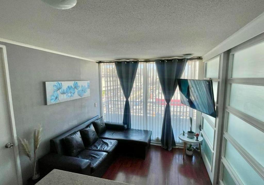 uma sala de estar com um sofá e uma grande janela em Departamento pleno centro de Viña del Mar em Viña del Mar