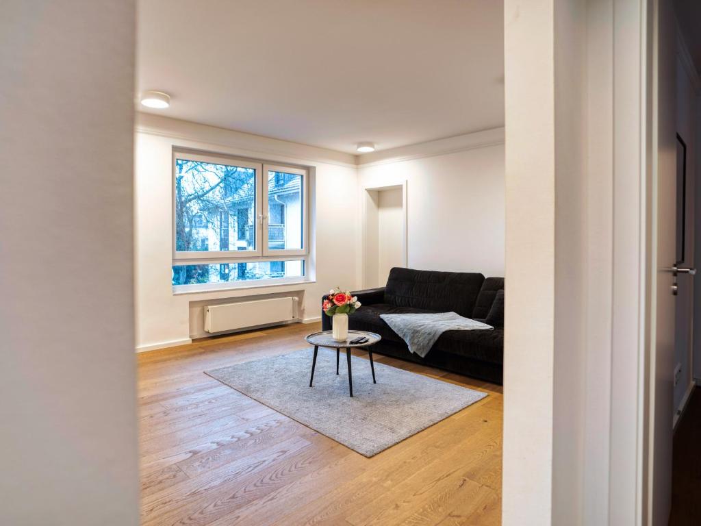 een woonkamer met een bank en een tafel bij Whirlpool - zentral - Designloft mit XXL Terrasse in Wiesbaden