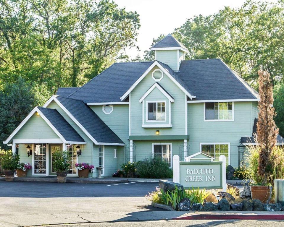 a blue house with a sign in front of it at Baechtel Creek Inn, Ascend Hotel Collection in Willits