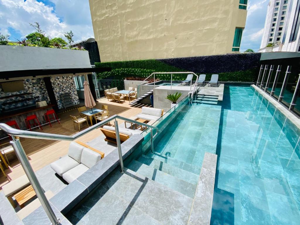 a swimming pool with chairs and a table at EON apartamentos in Guatemala