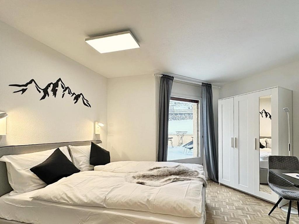 1 dormitorio con 1 cama con montañas en la pared en Im Zentrum, 2 Personen mit Garage (Pool) - CB102 en St. Moritz