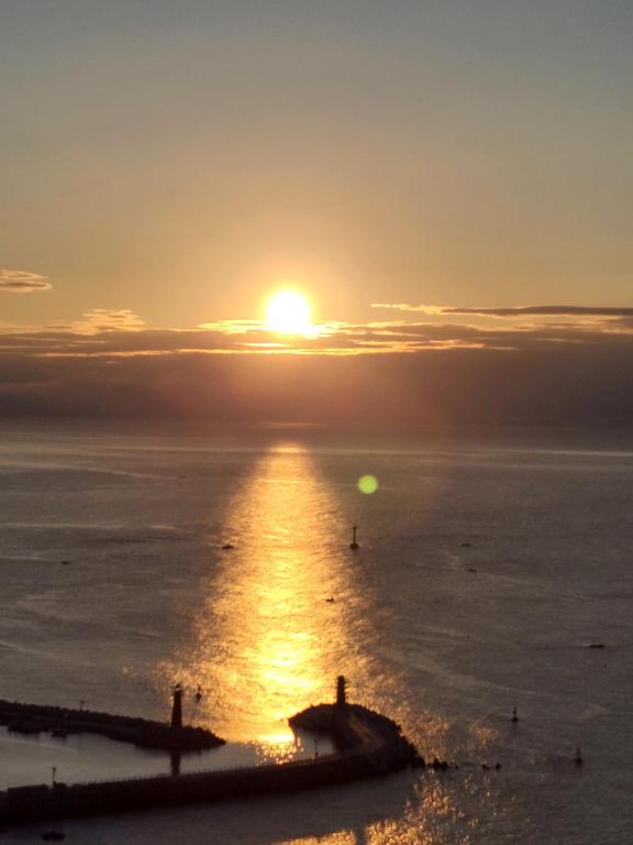 a sunset over the ocean with the sun in the sky at Suntree Hotel in Busan