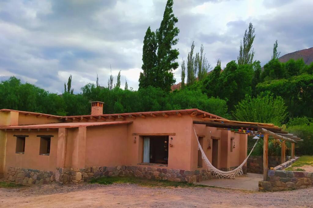 a small house with a hammock outside of it at La Casa de Tilcara in Tilcara