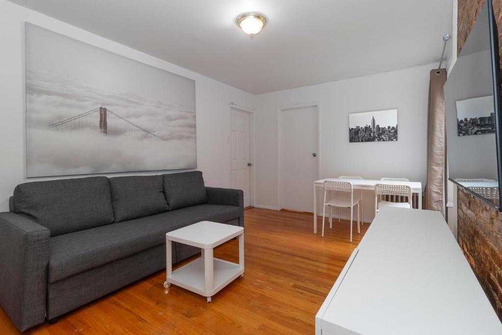 sala de estar con sofá y 2 mesas en The Upper East Side Monthly Rentals Apartments, en Nueva York
