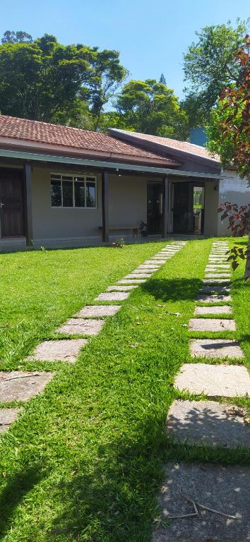 ein Haus mit einem Rasenplatz neben einem Gebäude in der Unterkunft Chácara novo mundo in Monte Sião