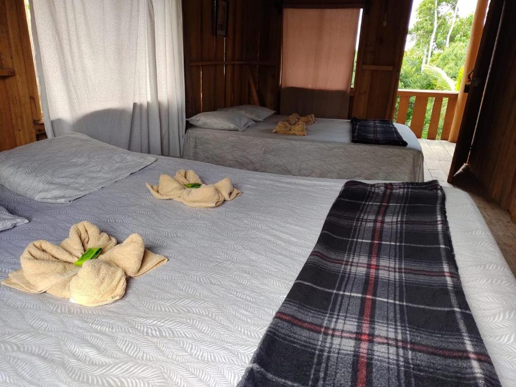 2 camas con toallas encima en Cabaña Familiar 7 Colinas, en San Vito
