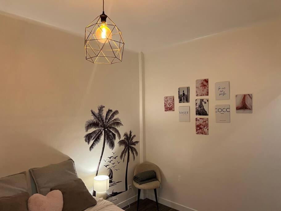 Sala de estar con sofá y palmera en la pared en Cosy studio south of Paris - MP52B, en París