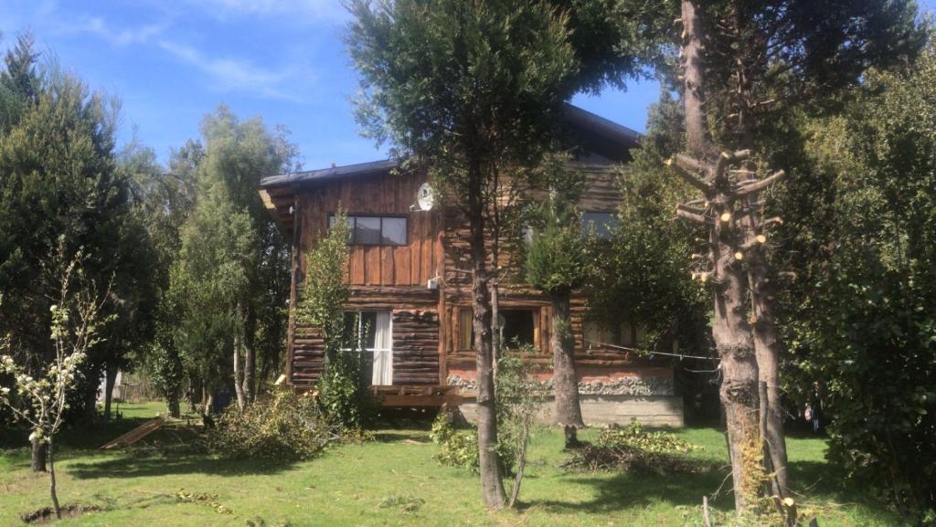a log cabin in the woods with trees at Lo de Flora Hostel in Los Repollos