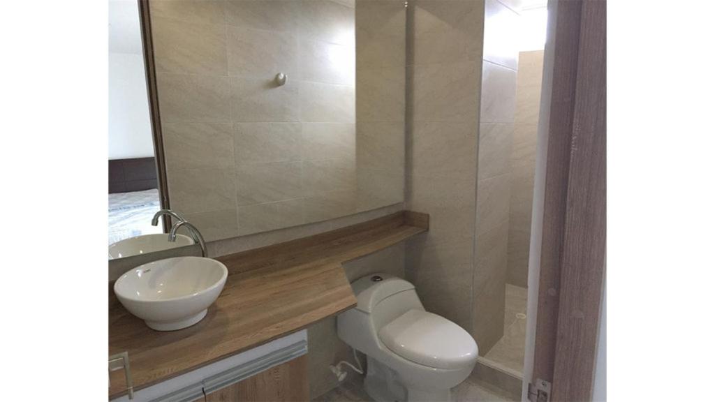 a bathroom with a sink and a toilet and a mirror at Casa 96 in Guatemala