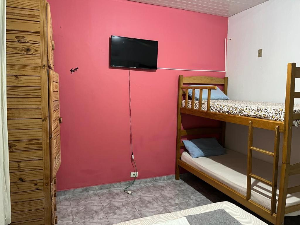 Zimmer mit 2 Etagenbetten und einem TV an der Wand in der Unterkunft Luso Apartamentos in Manaus