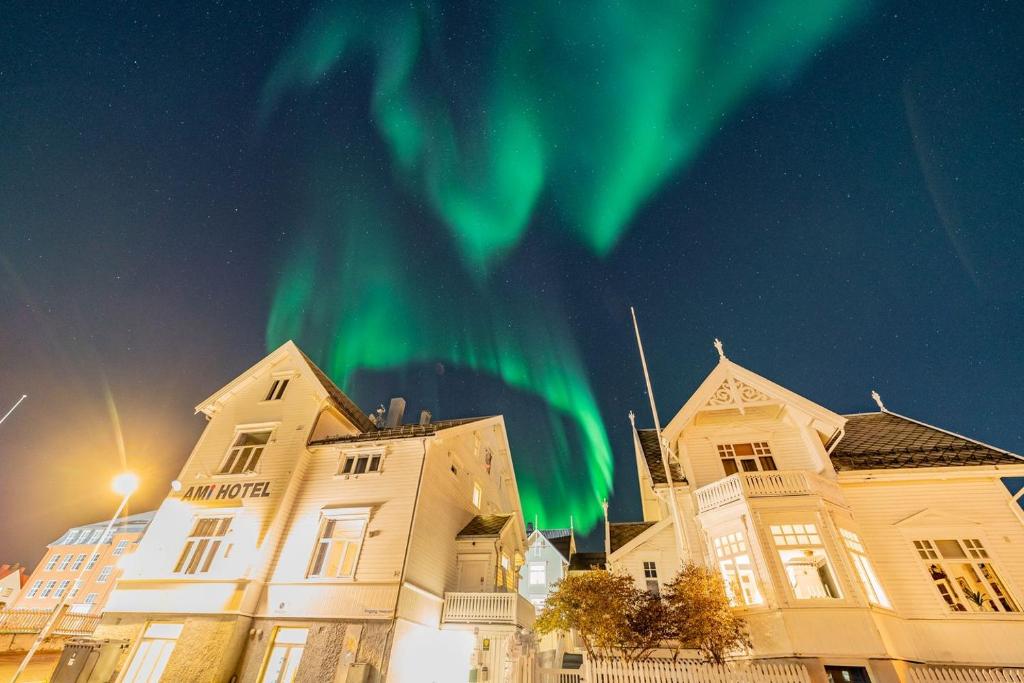 an apartment building with the aurora in the sky at Ami Hotel in Tromsø