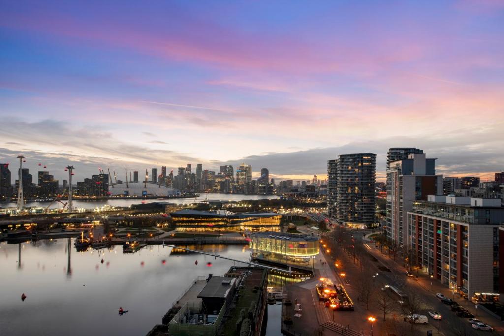 un profilo della città di notte con un fiume e edifici di Excel 3 Bedroom Apartment Near City Airport and O2 Arena a Londra