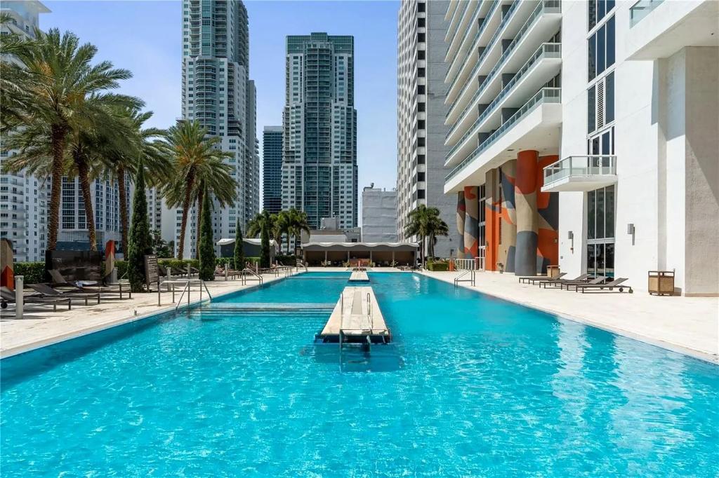 une grande piscine avec des palmiers et des bâtiments dans l'établissement Biscayne Bay View Stay Pool Hot Tub and Amenities, à Miami