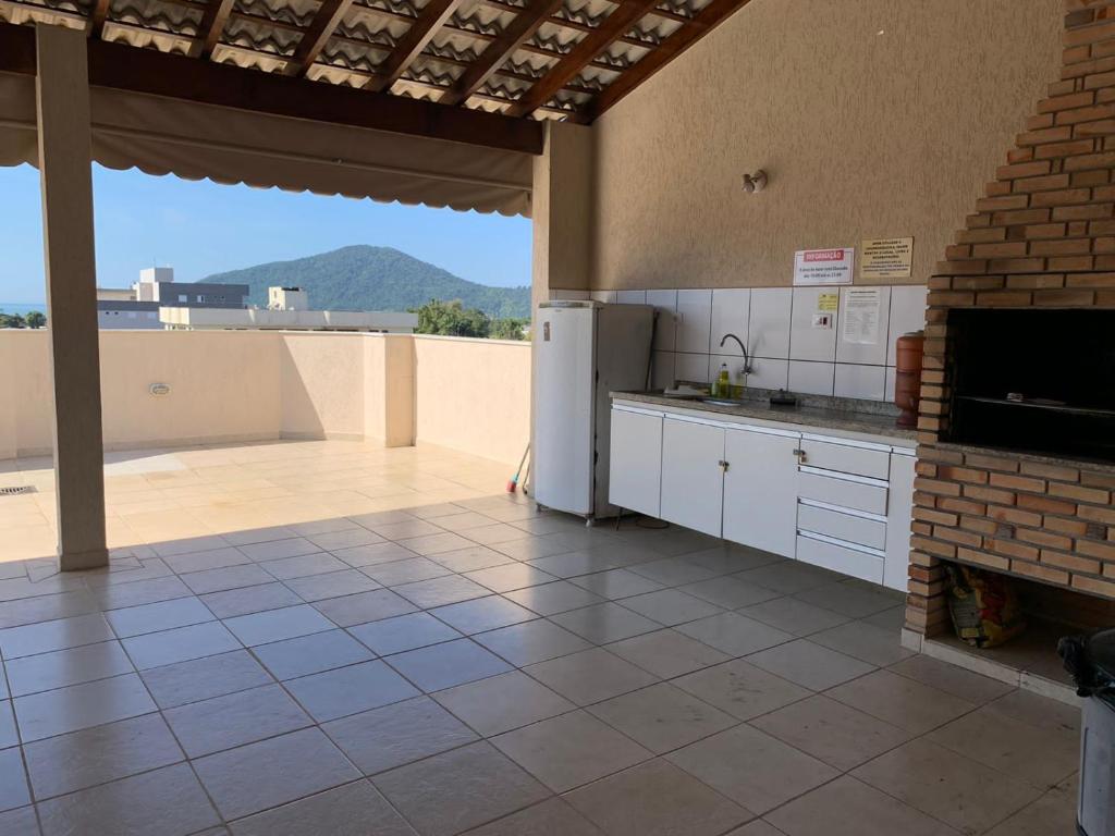 a kitchen with a refrigerator and a tile floor at Apê Carla Valéria in Ubatuba