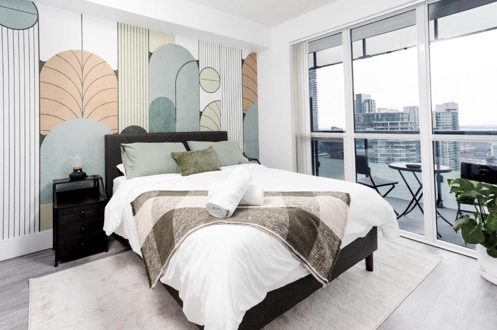 a bedroom with a large bed and a balcony at Stylish Suite at 300 Front Street W in Toronto