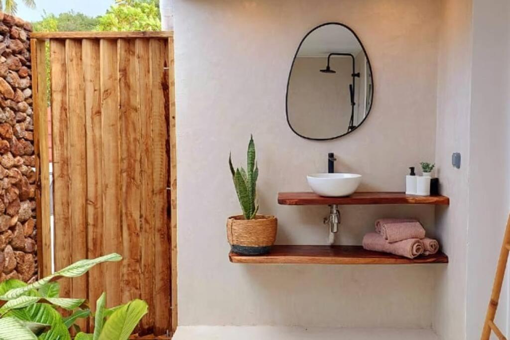 La salle de bains est pourvue d'un lavabo et d'un miroir mural. dans l'établissement ANAA Villa - Tropical experience, à Atiha