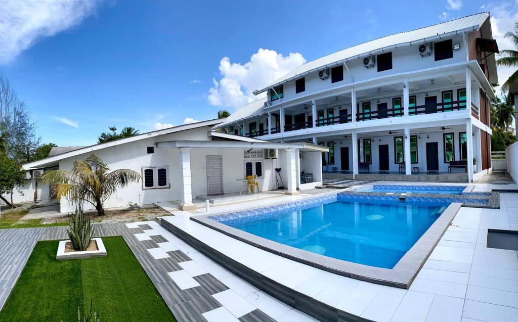 una gran casa blanca con piscina frente a ella en Fikri Wetland Guesthouse & Resort, 