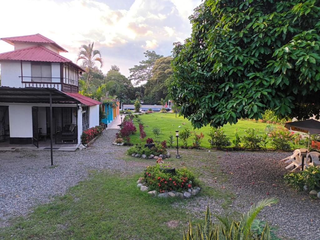 a garden in front of a house with flowers at HOSPEDAJE TURÍSTICO CAMPESTRE "VILLA ALONDRA" Parqueo Privado! in Villavicencio